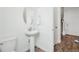 Modern powder room featuring a pedestal sink, oval mirror, and white fixtures at 1884 Myron Ct, Erie, CO 80516