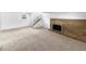 Open basement living space with a brick fireplace, stairs, and a window at 10930 Albion Ct, Thornton, CO 80233