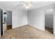 A clean, carpeted bedroom with a ceiling fan and view of a closet and bathroom at 10930 Albion Ct, Thornton, CO 80233