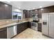 Modern kitchen with stainless steel appliances, granite countertops, dark cabinetry, and tile floors at 10930 Albion Ct, Thornton, CO 80233