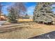 Large, partially fenced backyard with mature trees and lush greenery provides privacy and ample space for outdoor activities at 1173 Xenon St, Golden, CO 80401