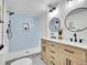 Luxurious bathroom boasts a double vanity, two round mirrors, and a walk-in shower with sleek blue tile accents at 1173 Xenon St, Golden, CO 80401