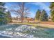 Spacious ranch-style house with a beautiful lawn, mature trees, and circular driveway on a sunny day at 1173 Xenon St, Golden, CO 80401