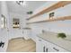 Well-lit laundry room with floating shelves, white countertops, and shaker cabinets at 1173 Xenon St, Golden, CO 80401