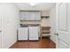 Laundry room with washer, dryer, cabinets, and wood floor at 1275 Exquisite St, Castle Rock, CO 80109