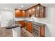 Basement kitchenette with dark granite counters, wood cabinets, and beverage refrigerator at 3751 W 136Th Ave # L1, Broomfield, CO 80023
