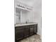 Bathroom featuring a double vanity with granite countertop, large mirror, and modern fixtures at 42853 Ivydel St, Elizabeth, CO 80107