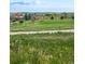 View of a manicured golf course and clubhouse in a residential community, ideal for golf enthusiasts at 42853 Ivydel St, Elizabeth, CO 80107