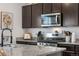 Modern kitchen featuring granite countertops, stainless steel appliances, and dark cabinets at 42853 Ivydel St, Elizabeth, CO 80107
