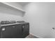 Functional laundry room with modern front-load washer and dryer and a shelf at 42853 Ivydel St, Elizabeth, CO 80107