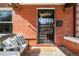 Inviting front porch featuring a cozy wicker bench, decorative pillows, and a 'hello' welcome mat at 1003 N Emerson St, Denver, CO 80218