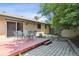 Brick home with a wooden backyard patio featuring a table and chairs with a stone path to the storage shed at 2901 Lorraine Ct, Boulder, CO 80304