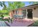 Brick home with a wooden backyard patio featuring a table and chairs for outdoor living and entertaining at 2901 Lorraine Ct, Boulder, CO 80304