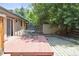 Brick home with a wooden backyard patio featuring a table and chairs with a stone path to the storage shed at 2901 Lorraine Ct, Boulder, CO 80304