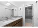 Double vanity bathroom with modern wood cabinets and a shower at 7177 W 8Th Ave, Lakewood, CO 80214