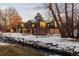 House exterior showcasing a unique architectural design, situated on a snowy landscape next to a stream at 7177 W 8Th Ave, Lakewood, CO 80214