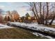 Modern house exterior with a covered patio and a view of a stream in a snowy setting at 7177 W 8Th Ave, Lakewood, CO 80214