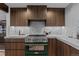 Gourmet kitchen with green range, marble backsplash and wood cabinetry at 7177 W 8Th Ave, Lakewood, CO 80214