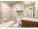 Well-lit bathroom features tiled shower-bath combination, toilet and vanity with sink at 2371 Pelican Bay Dr, Monument, CO 80132