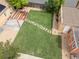 Aerial view of the fenced backyard featuring a green lawn, brick building, storage shed, and wooden deck at 2690 Magnolia St, Denver, CO 80207
