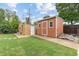 A backyard featuring a storage shed and brick building with a well-maintained green lawn at 2690 Magnolia St, Denver, CO 80207
