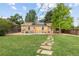 Spacious backyard with a stone walkway, green lawn, and a charming patio at 2690 Magnolia St, Denver, CO 80207