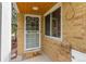 Front porch showcasing a white door, 'hello' mat, and brick siding at 2690 Magnolia St, Denver, CO 80207