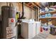 Basement laundry area with a washer, dryer, water heater, and storage shelves at 3685 S Hooker St, Englewood, CO 80110