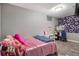 Bedroom featuring a bed with pink covers, gray walls, and a desk area with ample lighting at 3685 S Hooker St, Englewood, CO 80110