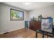 Bedroom showcasing wood floors, a large window, and a dresser with multiple aquariums at 3685 S Hooker St, Englewood, CO 80110