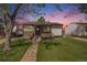 Charming single-story home with a well-manicured lawn, stone accents, and beautiful evening sky at 3685 S Hooker St, Englewood, CO 80110
