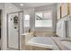 Bright bathroom featuring a glass shower, soaking tub, and neutral tile surround at 8839 Culebra St, Arvada, CO 80007