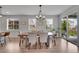Dining area features a wood dining table and modern lighting fixture and sliding glass doors to outside at 8839 Culebra St, Arvada, CO 80007