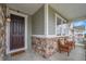 Inviting covered front porch with stone detail, cozy seating and a welcoming front door at 8839 Culebra St, Arvada, CO 80007