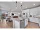 Modern kitchen with stainless steel appliances, white cabinets, and an island open to the dining and living areas at 8839 Culebra St, Arvada, CO 80007