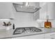 Close up of modern gas range and sleek hood, set against a backdrop of white subway tiles and countertops at 8839 Culebra St, Arvada, CO 80007