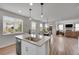 Open concept kitchen with a large island, stainless steel appliances, and seamless flow to dining and living spaces at 8839 Culebra St, Arvada, CO 80007