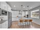 Modern kitchen with stainless steel appliances, white cabinets, an island, and pendant lighting at 8839 Culebra St, Arvada, CO 80007
