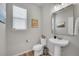 Stylish powder room with modern fixtures, a pedestal sink, and a decorative mirror at 8839 Culebra St, Arvada, CO 80007