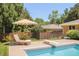 Inviting backyard featuring a swimming pool, lounge chairs, and lush landscaping at 3025 S Norman Ct, Denver, CO 80224