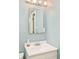 Cozy bathroom with white sink, vanity, and a classic mirror with stylish light fixture at 3025 S Norman Ct, Denver, CO 80224