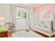 Charming Bedroom with swan mural, white crib, and bright natural light at 3025 S Norman Ct, Denver, CO 80224