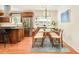 Bright dining room boasts a modern light fixture, glass table, and wood accents at 3025 S Norman Ct, Denver, CO 80224