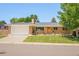 Charming single-story brick home with a well-manicured lawn and an attached two-car garage at 3025 S Norman Ct, Denver, CO 80224
