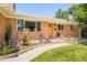Lovely brick home with landscaped garden beds and a curved walkway leading to the front door at 3025 S Norman Ct, Denver, CO 80224