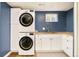 Modern laundry room with stacked washer/dryer and utility sink at 3025 S Norman Ct, Denver, CO 80224