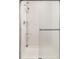 Shower stall featuring white tiling, sleek glass door, and convenient shelving at 3025 S Norman Ct, Denver, CO 80224