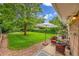 Enjoy this backyard with a large green lawn, patio, and mature trees, perfect for relaxation and entertaining at 962 S Potomac Way, Aurora, CO 80012