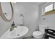 Charming powder room featuring a round mirror and a clean, modern toilet at 962 S Potomac Way, Aurora, CO 80012