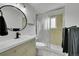 Modern bathroom featuring a vanity, shower with glass doors, and a round mirror at 962 S Potomac Way, Aurora, CO 80012